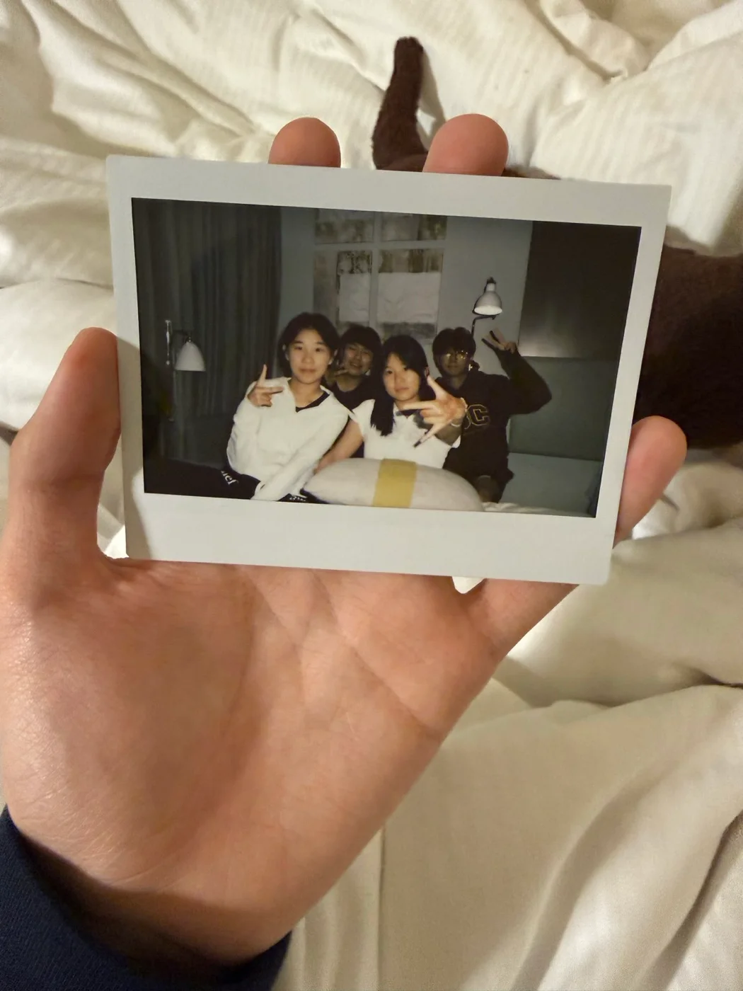 A hand holding a group photograph