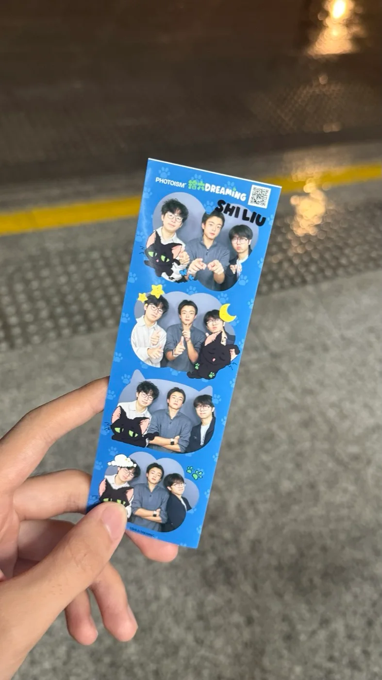 A hand holding a blue photo-booth strip